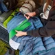 Découpe aux ciseaux d'une bande de ruban vert de la gamme avant la réparation d'une doudoune
